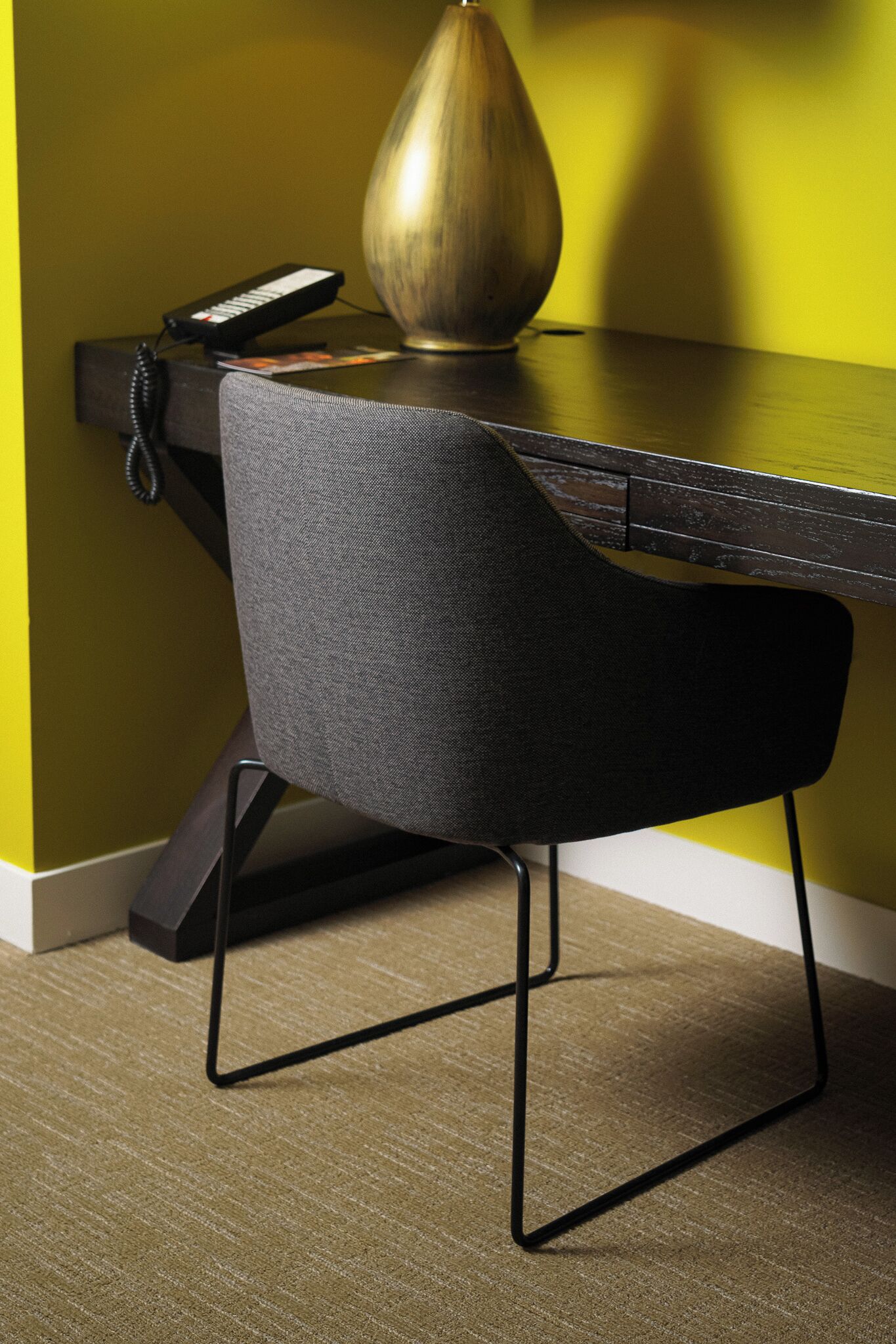 Un bureau moderne avec un téléphone et un vase décoratif.