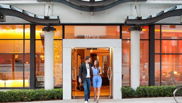 A hotel entrance with a modern design, featuring a glass facade and a sign that reads "OPUS". - OPUS Hotel Vancouver (Vancouver)