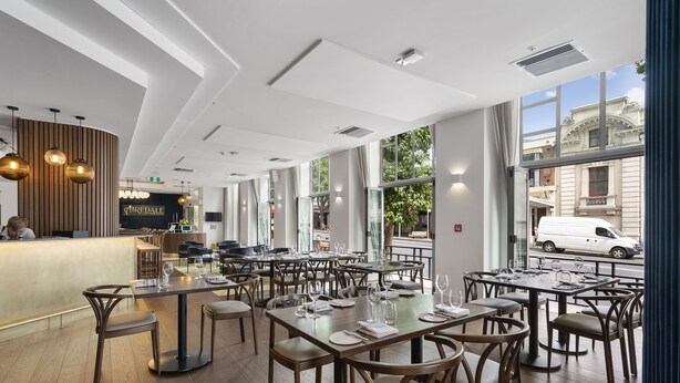 A modern restaurant interior with high ceilings, large windows, and a variety of seating arrangements. - Legacy Airedale Hotel Auckland (Auckland)