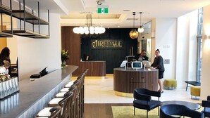 A modern hotel lobby with a reception desk, bar area, and seating. - Legacy Airedale Hotel Auckland (Auckland)