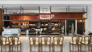 A bar area with a counter, bar stools, and shelves stocked with bottles and glasses. - Legacy Airedale Hotel Auckland (Auckland)