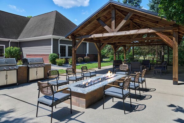 An outdoor patio with a fire pit, seating, and a grill area. - Residence Inn By Marriott Flint (Flint)