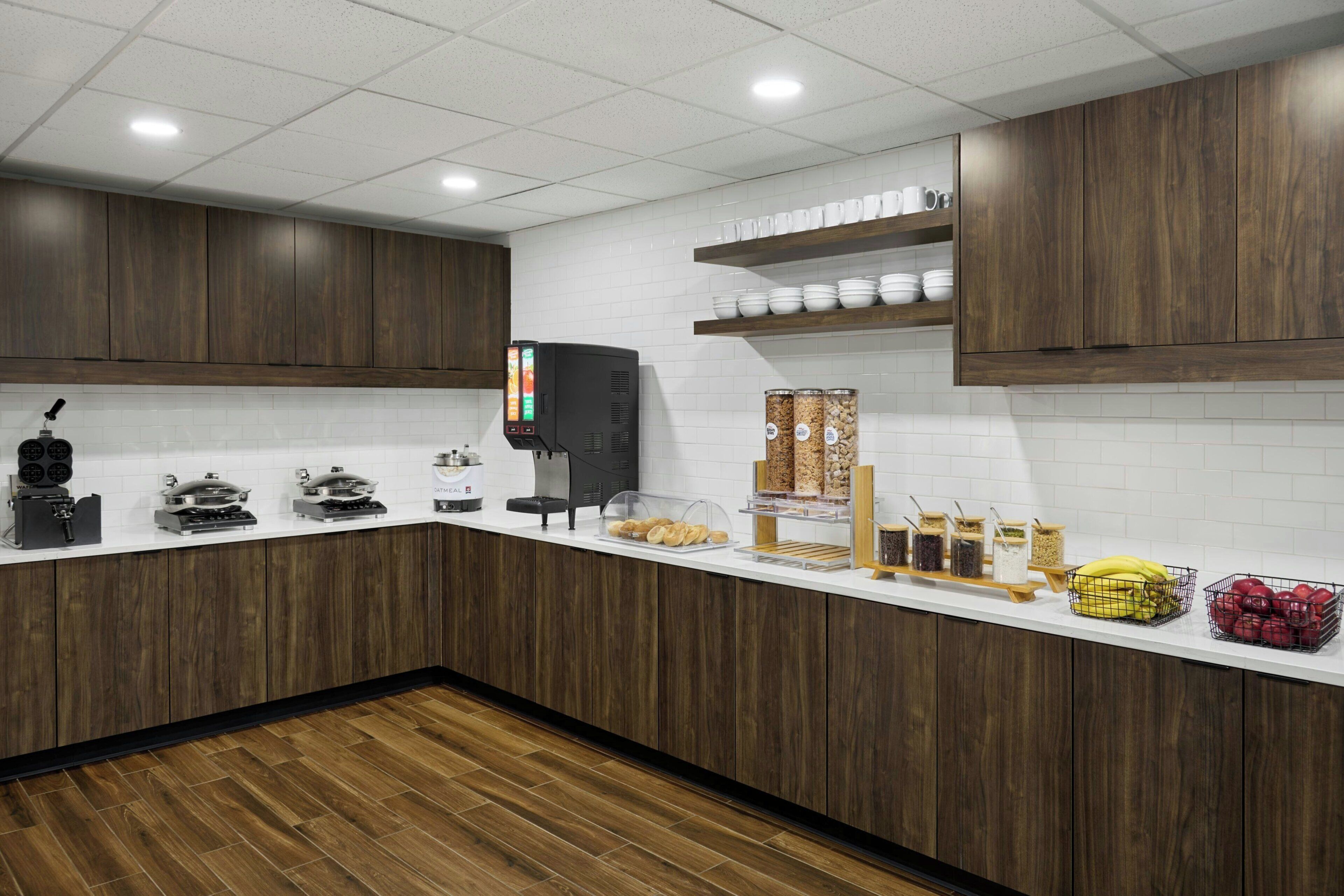 Una cocina moderna con armarios de madera, una cafetera y varios alimentos sobre la encimera.