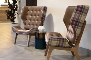 Two leather armchairs with plaid upholstery and a small round table between them. - Residence Inn by Marriott Tampa Westshore/Airport (Tampa)