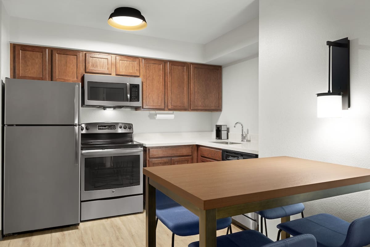 1 habitación, escritorio y tabla de planchar con plancha