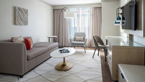Ein modernes Hotelzimmer mit einer Couch, einem Sessel und einem kleinen Tisch.