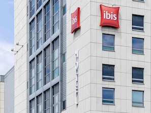 A building with a modern facade, featuring two prominent red 'ibis' signs indicating the presence of an ibis hotel. - ibis Berlin Spandau (Berlin)