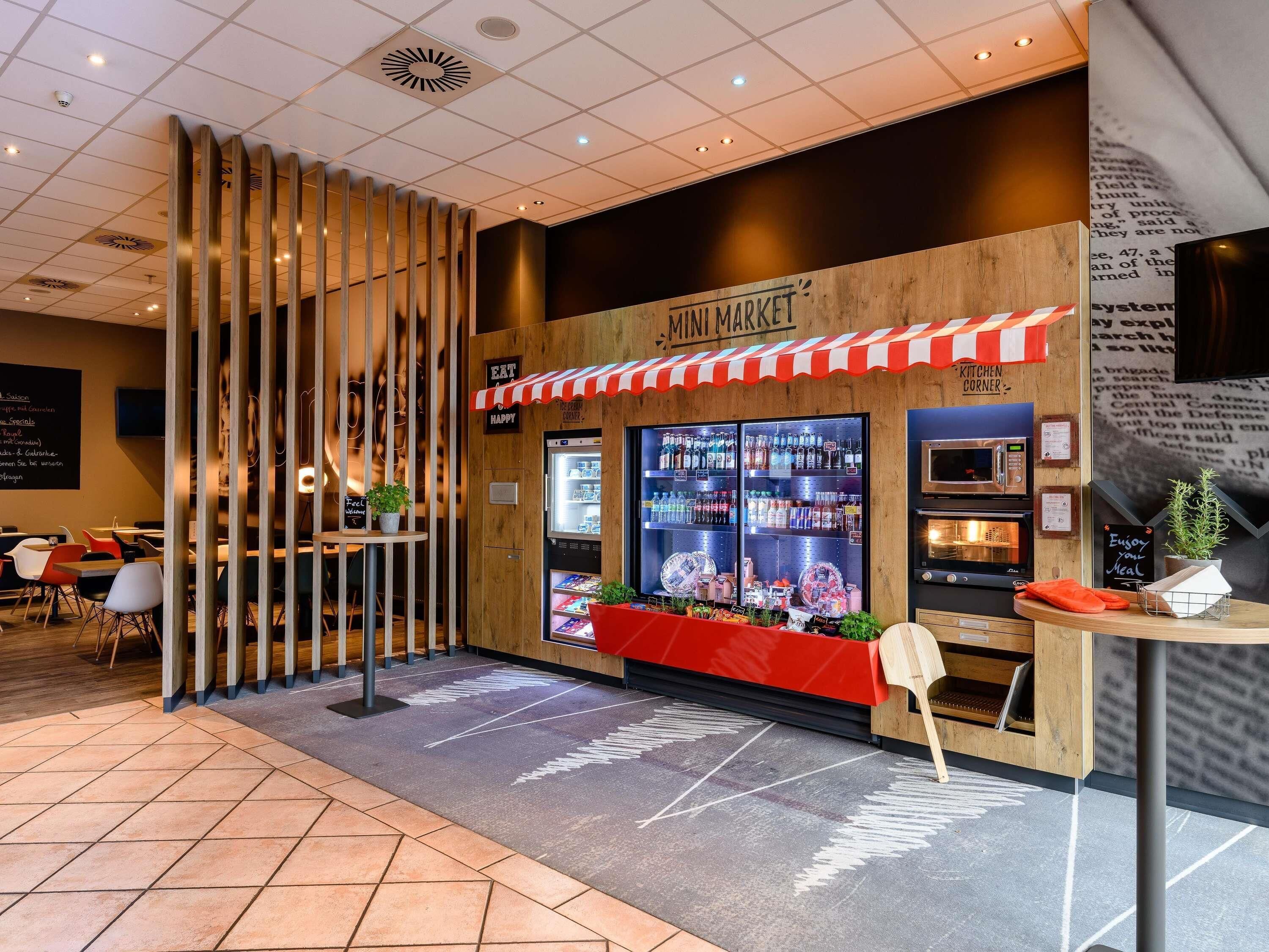 A mini market with a refrigerated display and a kitchen corner.