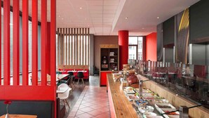 Un restaurante moderno con una barra larga, detalles en rojo y una zona de bufé con diversas opciones de comida.