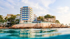 Un hotel frente al mar con varios pisos y balcones.