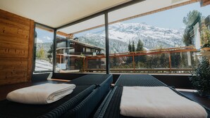 A modern room with large windows offering a mountain view. - Hotel Schweizerhof Gourmet & Spa (Saas-Fee)