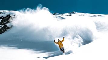 Un snowboarder con una chaqueta amarilla en una montaña nevada.
