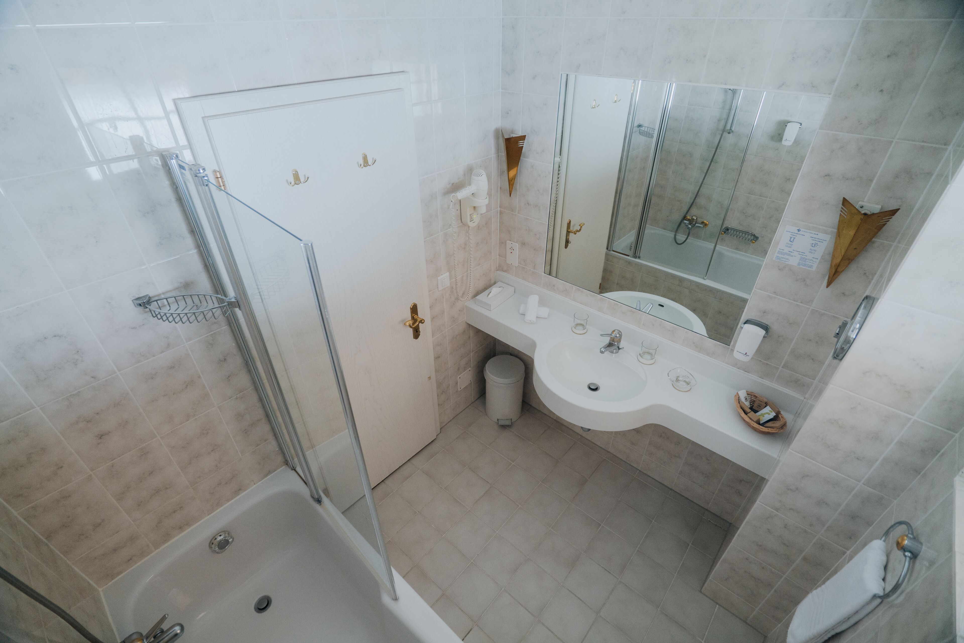 Un baño con ducha, bañera, lavabo y espejo.