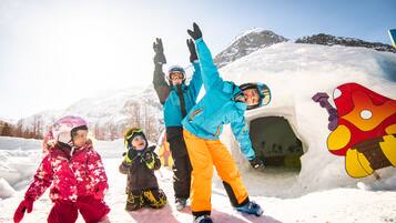 Eine Gruppe von Menschen in verschneiter Landschaft mit einem Schneemann und einer Schneemannfigur.