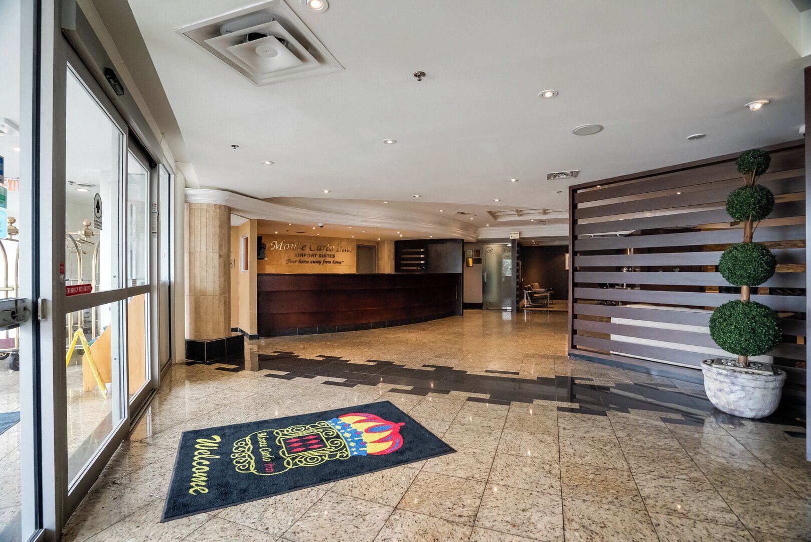 A hotel reception area with a reception desk, a waiting area, and a reception desk with a sign that reads "Monte Carlo Inn."