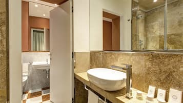 Un baño moderno con un lavamanos grande, una ducha y un espejo.