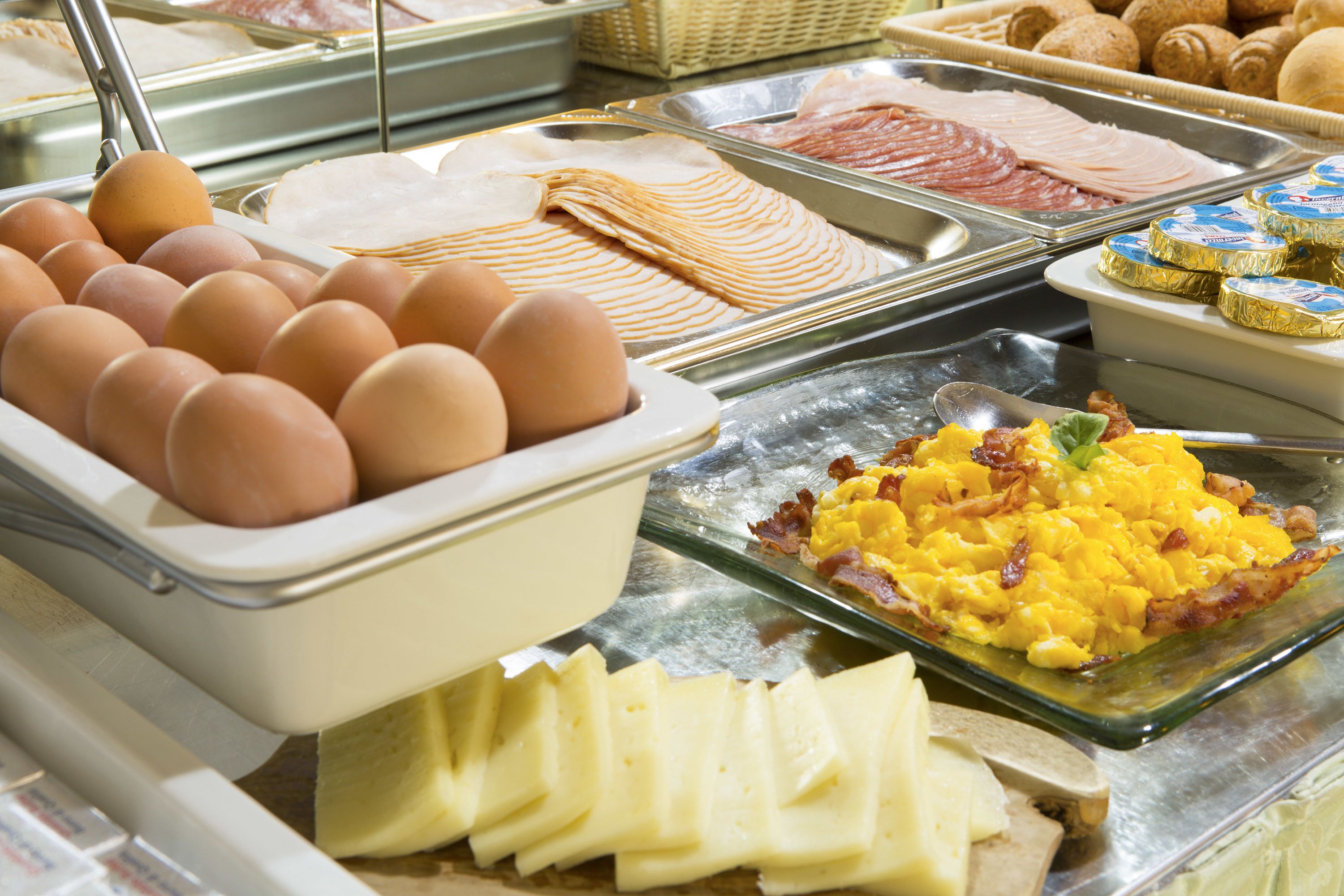 A buffet with various food items including eggs, cheese, and meats.