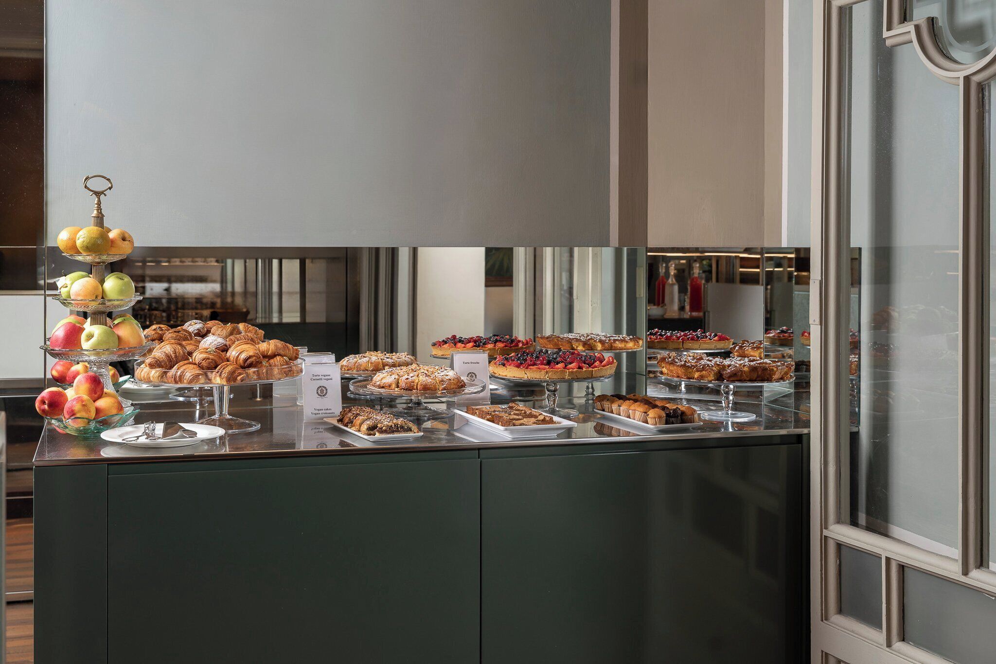 A buffet with various pastries, fruits, and desserts.