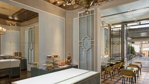 Um restaurante moderno com ilha central, divisórias de vidro e área de refeições com cadeiras e mesas.