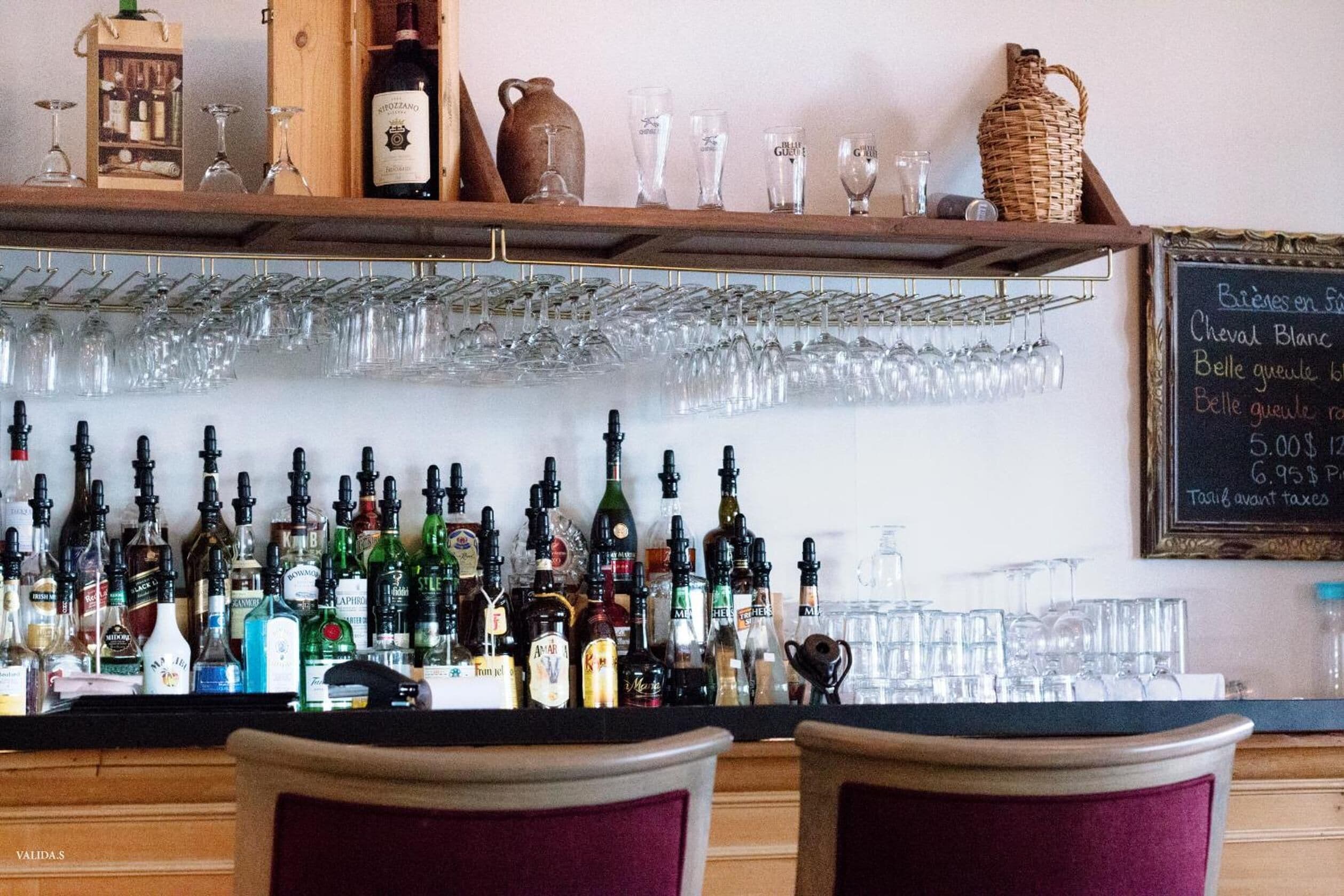 A bar area with a variety of liquor bottles and glasses.
