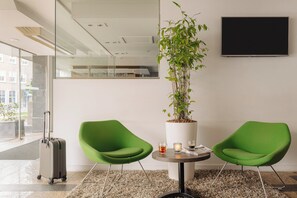 Relax in comfort with a large potted plant, two chairs, and a flat-screen TV.