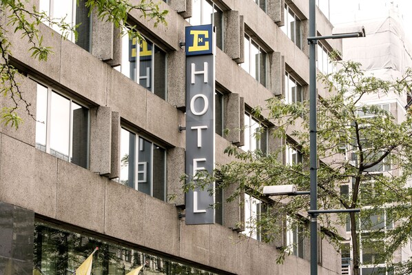 Hotel entrance with a prominent sign and modern architecture.