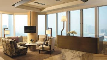 Una sala moderna con un televisor de pantalla plana, un sofá, una mesa de centro y un comedor.