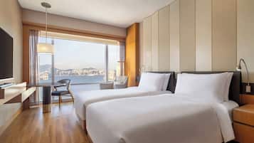 Ein Hotelzimmer mit zwei Betten, einem Schreibtisch und einem Sessel.