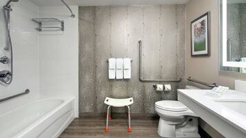 A modern bathroom with a bathtub, toilet, and shower.