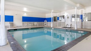 An indoor swimming pool with a tiled edge, a blue wall, and a white ceiling. - Quality Inn Kearney - Liberty (Kearney)
