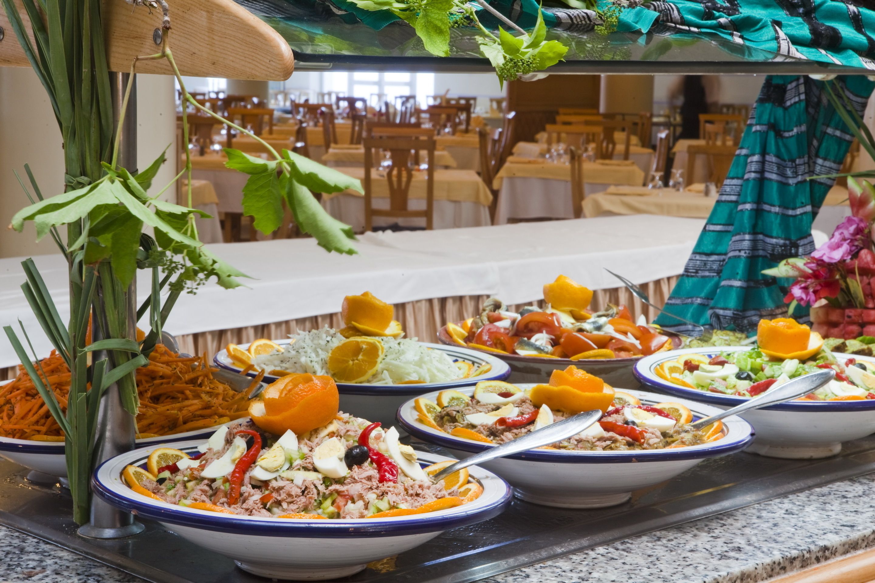 A buffet with various dishes and a decorative plant.