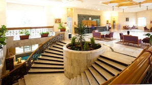 A spacious lobby with a central staircase, seating areas, and a reception desk. - El Mouradi Djerba Menzel (Aghir)