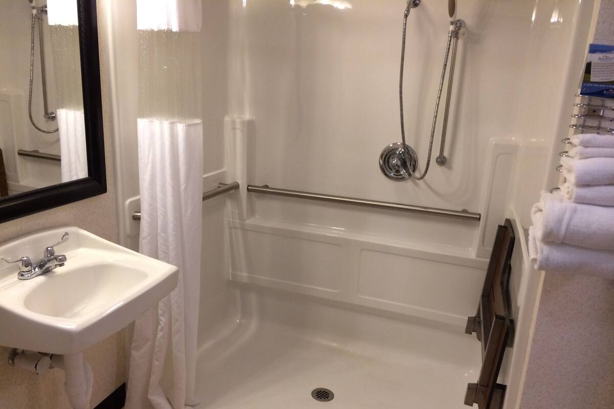 A bathroom with a white sink, a glass shower enclosure, and a bathtub.