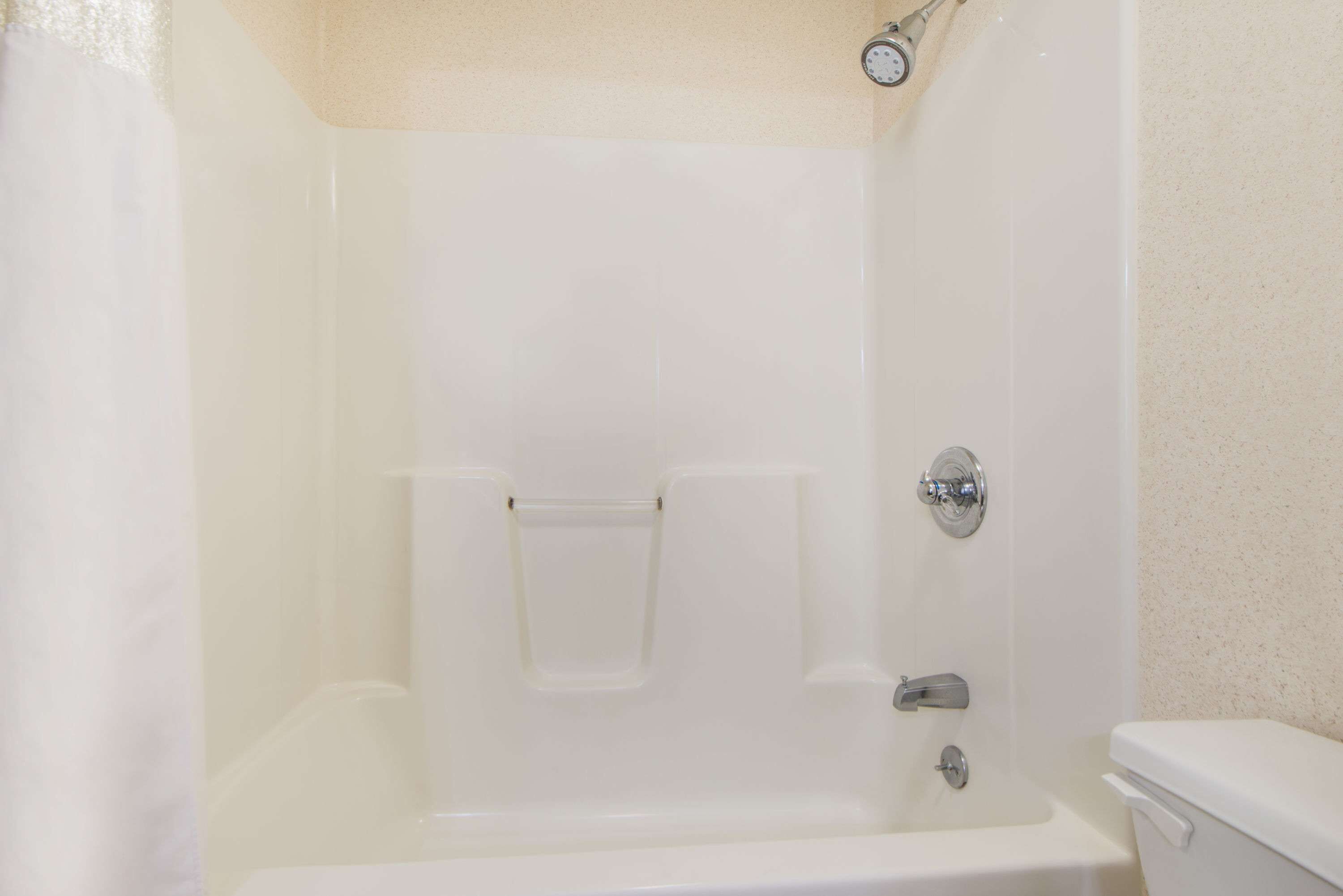 Une salle de bain blanche avec une baignoire, des toilettes et une douche.