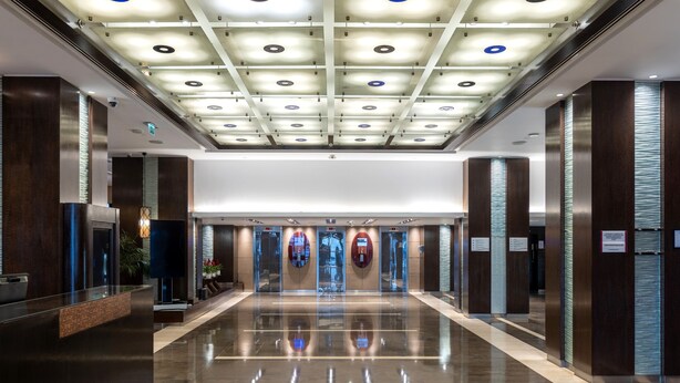 A modern hotel lobby with a reflective floor, a reception desk, and a ceiling with recessed lighting. - Crowne Plaza Amman by IHG (Amman)