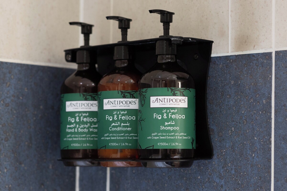 Three bottles of Antipodes products: Fig & Feijoa Hand & Body Wash, Fig & Feijoa Conditioner, and Fig & Feijoa Shampoo, each with a pump dispenser.