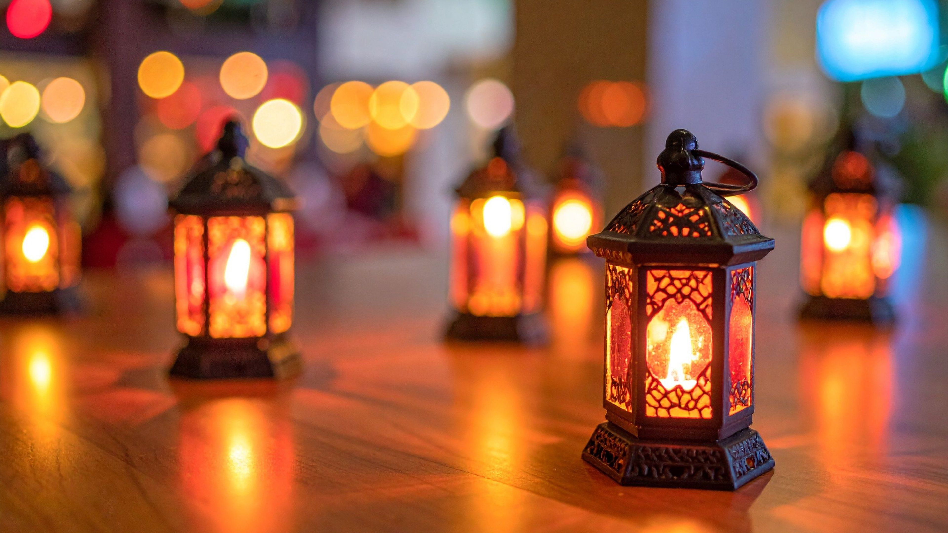 A row of lit lanterns on a wooden floor.