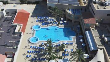 A rooftop pool area with multiple sun loungers and a central swimming pool.