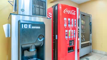 Een automaatruimte met een ijsblokjesdispenser en een Coca-Cola automaat.