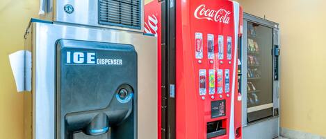 Zona de máquinas expendedoras con dispensador de hielo y máquina expendedora de Coca-Cola.
