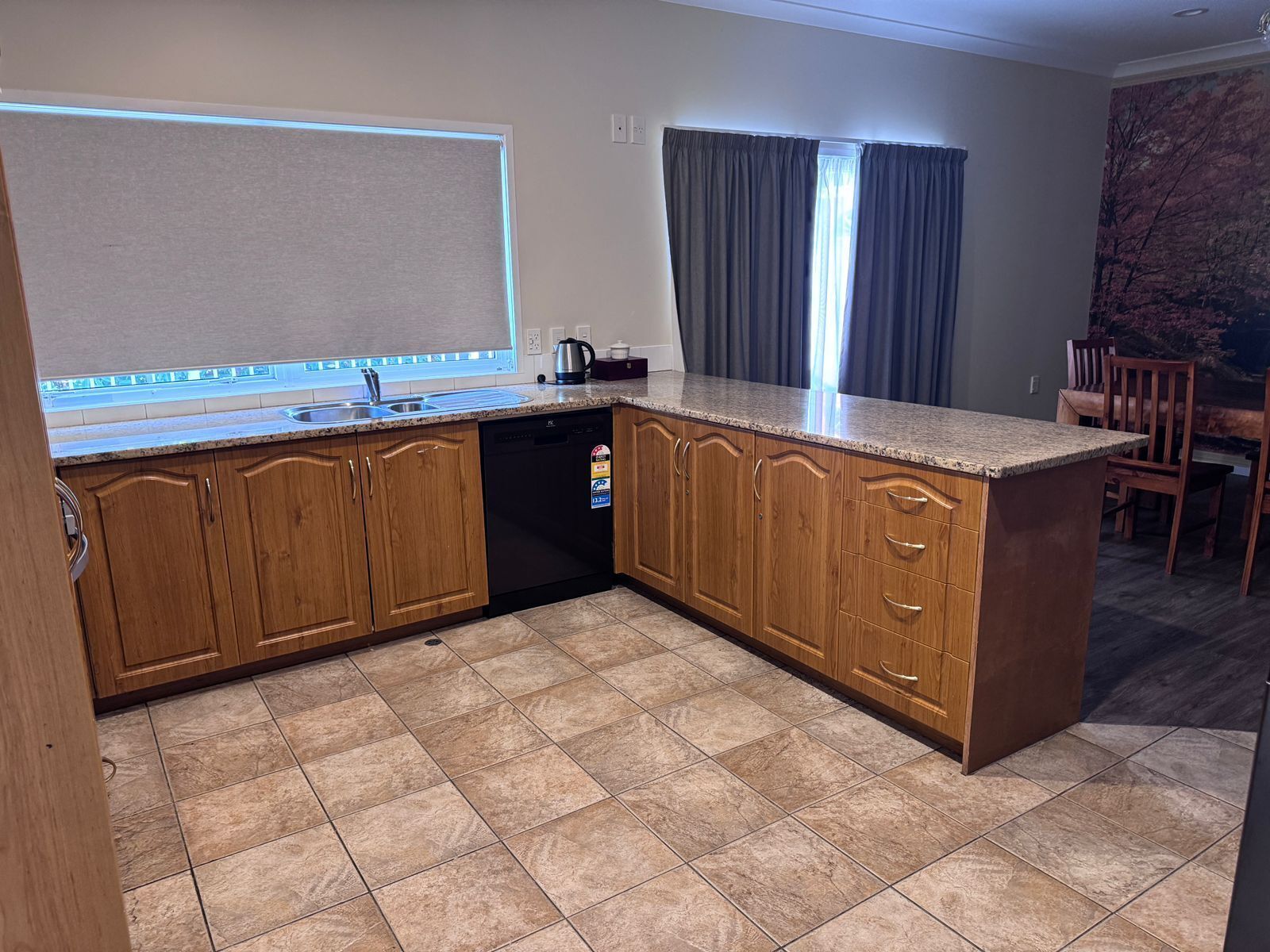 A kitchen with wooden cabinets, a built-in dishwasher, and a granite countertop.