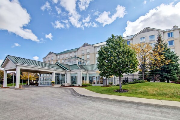 A hotel with a covered entrance, multiple floors, and a well-maintained lawn. - Hilton Garden Inn Toronto - Mississauga (Mississauga)