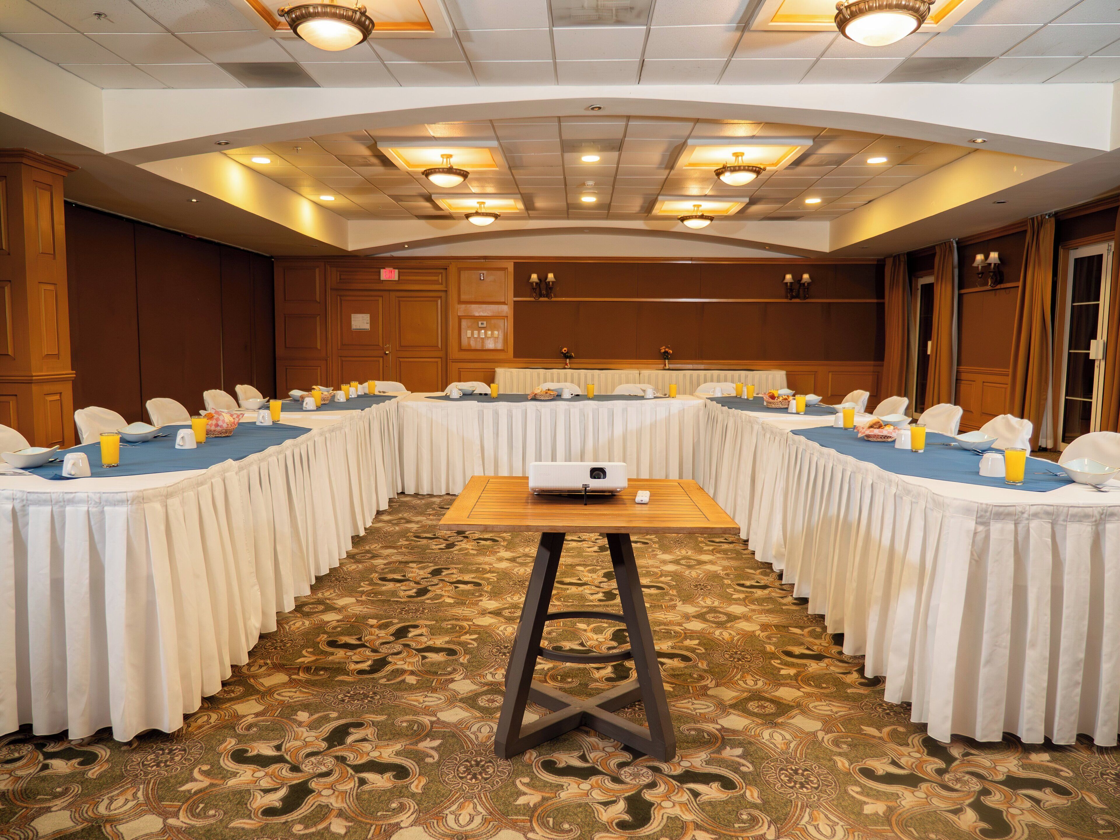 A conference room with a long table, chairs, and a projector.