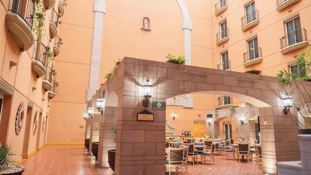 Un vaste atrium doté d’une arche centrale, d’un sol carrelé et de plusieurs espaces aménagés pour s’asseoir.