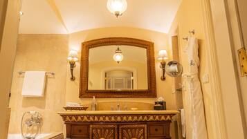 A bathroom with a large mirror, vanity, bathtub, and a towel rack.