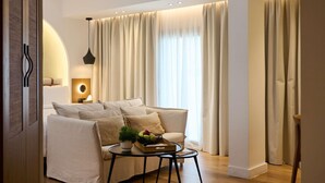 Un salon moderne avec un canapé, une petite table ornée d’une plante et une lampe.
