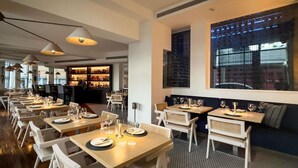 Un restaurant doté de nombreuses tables, de chaises et d’un bar.