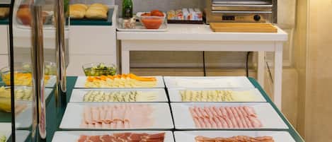 A buffet with various food items including meats, cheeses, and vegetables.
