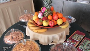 A buffet table with a variety of food items including fruits, pastries, and packaged snacks. - Hotel Quinta das Pratas (Cartaxo)