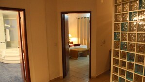 A hotel room with a bathroom, a bed, and a glass block partition. - Hotel Quinta das Pratas (Cartaxo)
